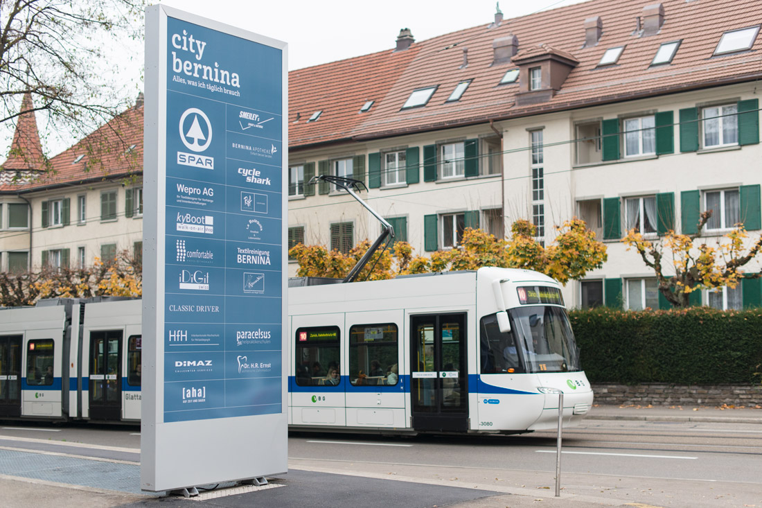 Blaue grosse Stele an der Strasse, beschriftet mit Mieterbeschriftung