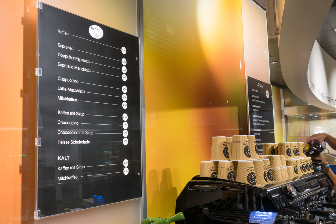 Raumgestaltung Gastronomie mit schwarzen Menuetafeln auf oranger Wand mit Frischelook