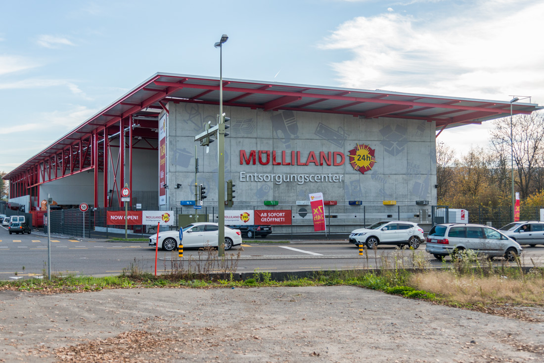 Süd-West-Ansicht der Fassadenbeschriftung Muelliland, Entsorgungscenter mit leuchtender Sonne mit natuerlichem Lichteffekt