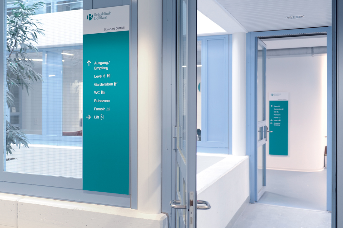 Wegweiser im Provisorium der Klinik: Stele auf Glas aus Alu-Dibond