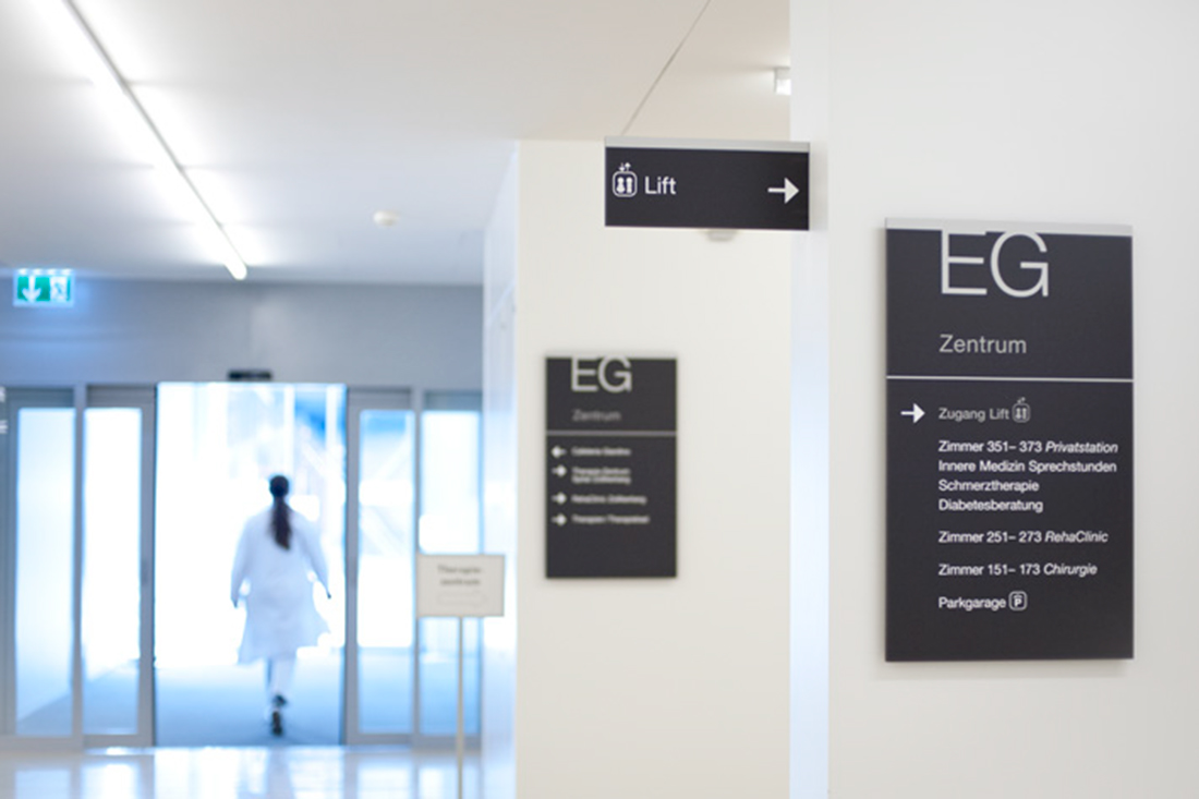 Orientierungssystem-Design Schilder an der Wand und Stechschilder bilden eine harmonierende Signaletik