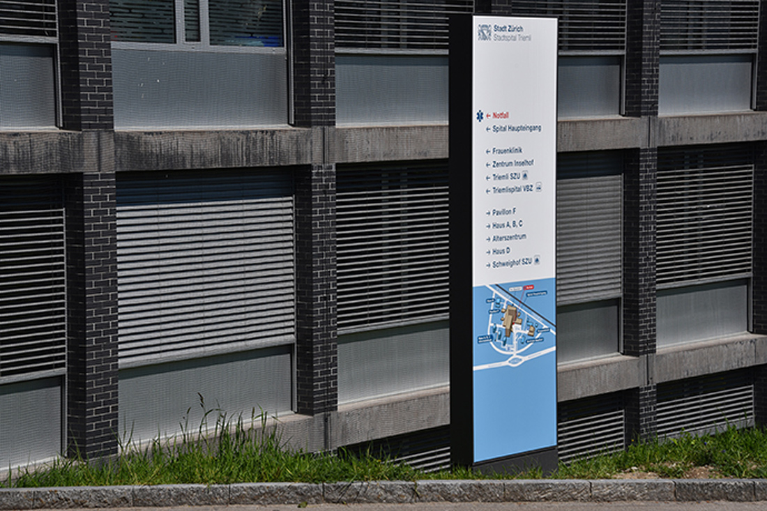 Stele mit Orientierungsplan und Wegweisung vor dem Spital