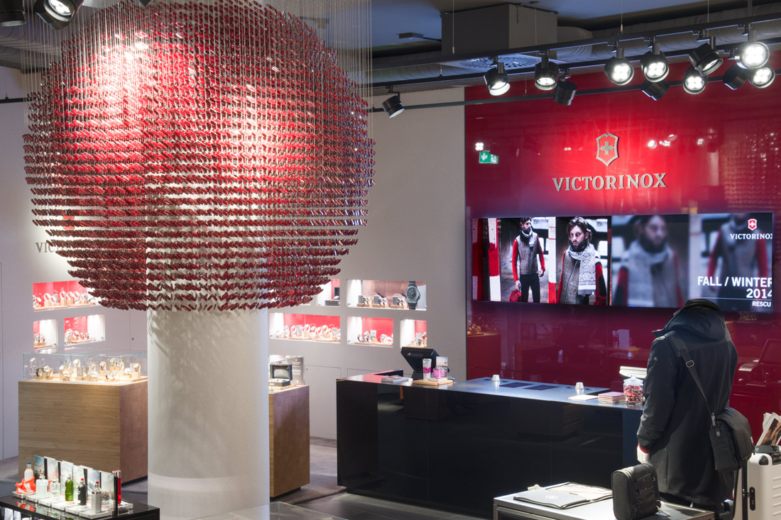 Pos-Dekoration im Flagship-Store von Victorinox: Beleuchteter Globus aus Sackmessern glaenzend Rot vor der Verkaufstheke