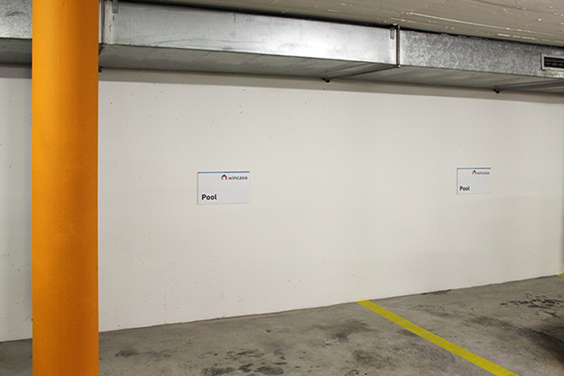 Parkplatzschilder mit verdeckter Montage an die Wand angebracht