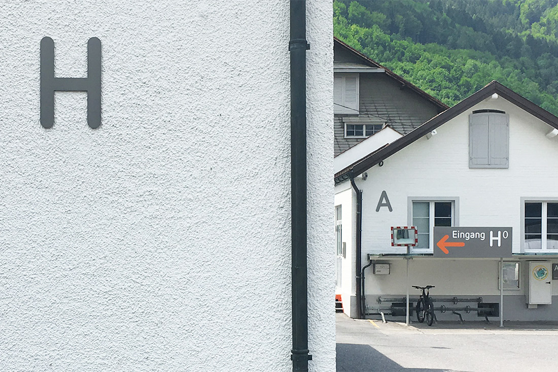 3D Buchstaben an der Fassade erleichtern die Orientierung. Stechschild mit wegweisendem Pfeil.