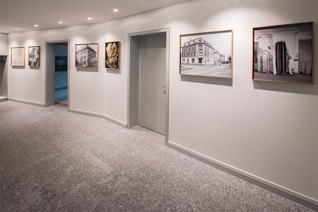 LED-Deckenspots im Erdgeschoss mit Granitboden und historischen Aufnahmen an der Wand